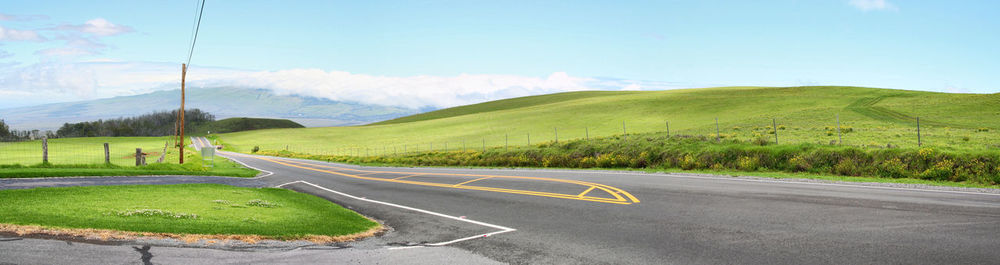 Road by mountains against sky