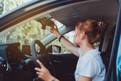 Midsection of woman using smart phone in car