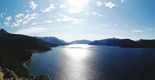Scenic view of sea by mountains against sky