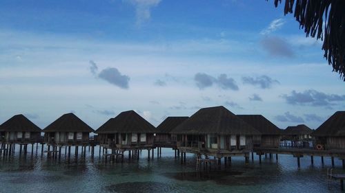 View of houses by sea against sky