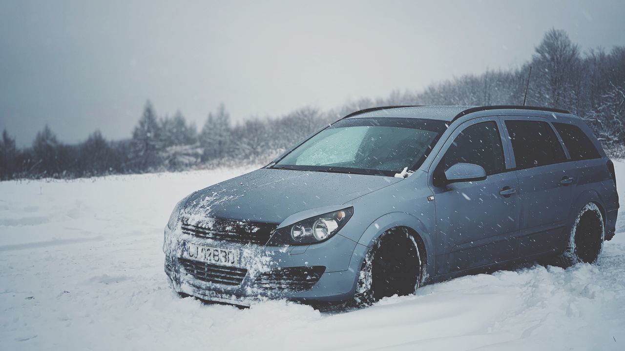 SNOW COVERED LAND AND CARS ON FIELD