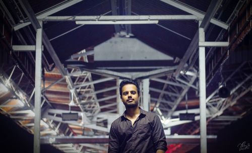 Portrait of man standing at railroad station