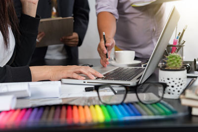 Midsection of business people working on table