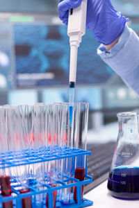 Cropped hand of scientist pippeting at laboratory