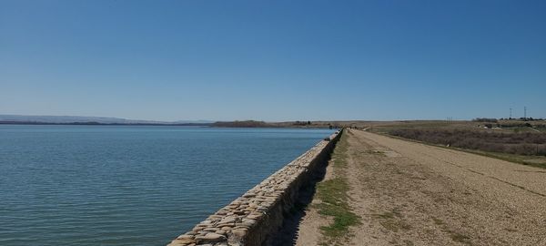 Scenic view of road against clear blue sky