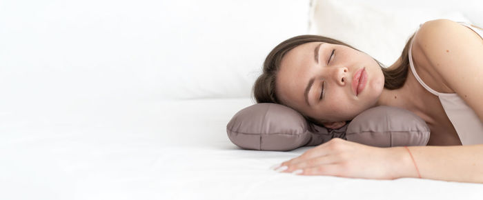 Caucasian girl sleeping on a special beauty pillow with a silk pillowcase. banner