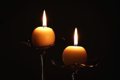 Close-up of illuminated candles in darkroom
