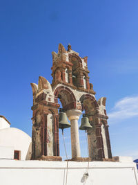 Low angle view of bell tower against blue sky