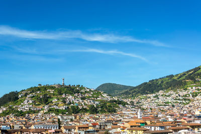 Cityscape by mountains against sky