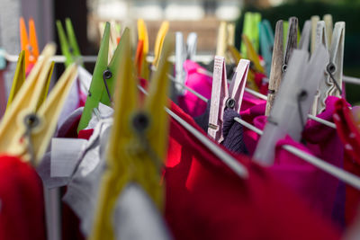 Close-up of textiles attached to pins on clotheslines