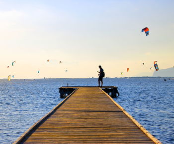 Men flying over sea against sky