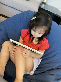 High angle view of woman sitting on book