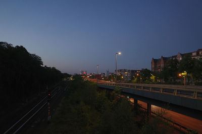 Light trails on street against sky at dusk