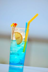 Close-up of drink on glass against blue sky