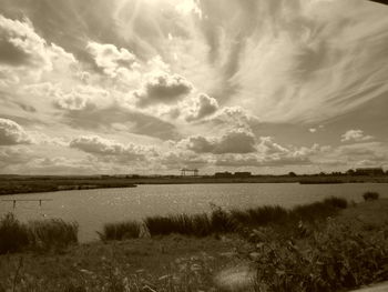 Scenic view of calm lake against cloudy sky