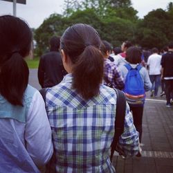 Rear view of people walking on road