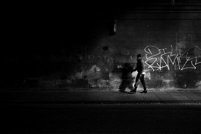 Man and woman standing on wall at night