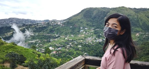 Portrait of beautiful young woman standing on mountain