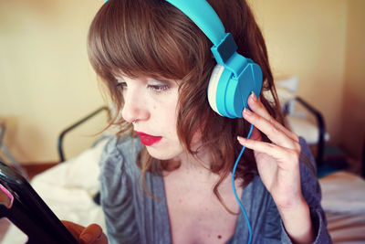 Close-up of woman listening to music through headphones