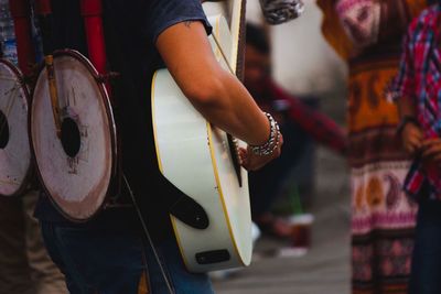 Midsection of person playing guitar outdoors