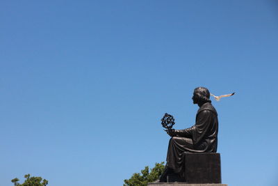 Low angle view of statue against clear blue sky