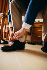 Low section of man wearing shoe on floor