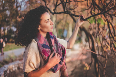 Young woman standing on tree trunk