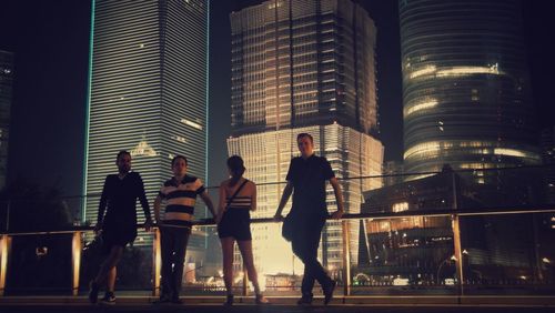 Woman standing in city at night