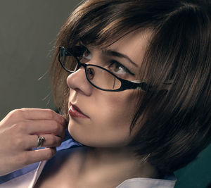 Close-up of beautiful woman standing against gray background