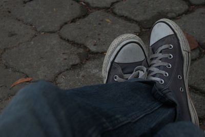 Low section of man standing on tiled floor