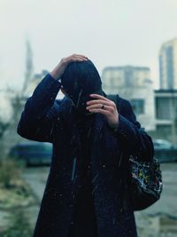 Man wearing cap during rainy season while standing outdoors