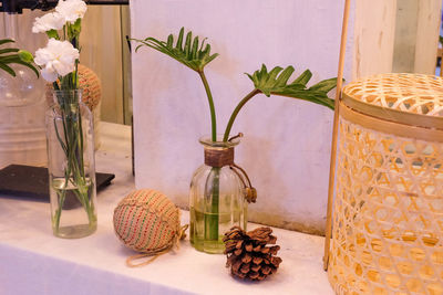 Close-up of vase on table against wall at home