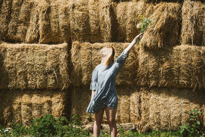 Woman standing by plants on field