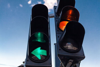 Low angle view of road signal against sky