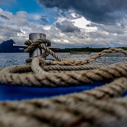 Close-up of rope tied on beach against sky