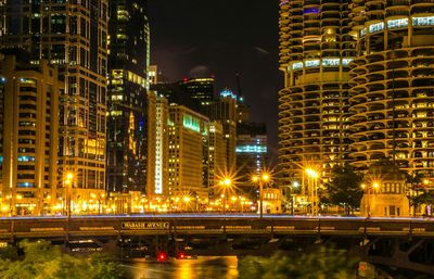 Illuminated city against sky at night