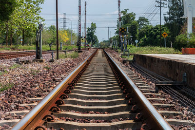 Railroad tracks by trees against sky