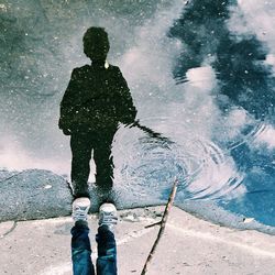 Reflection of people in puddle