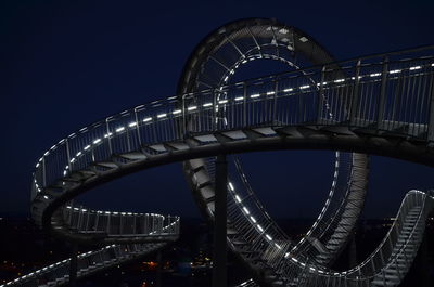 Low angle view of illuminated bridge against sky at night