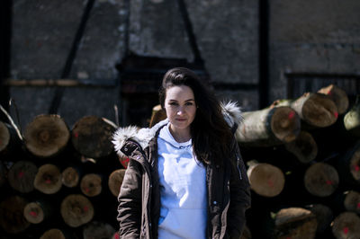 Portrait of smiling young woman standing logs