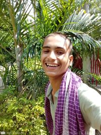 Portrait of smiling man standing against plants