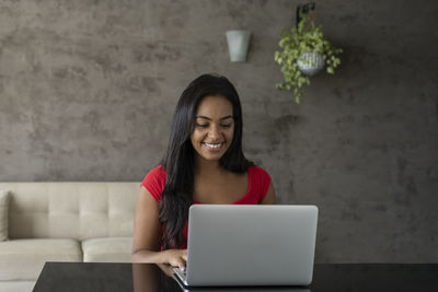 Young black woman working at home with laptop on desk. home office concept. gray notebook. 