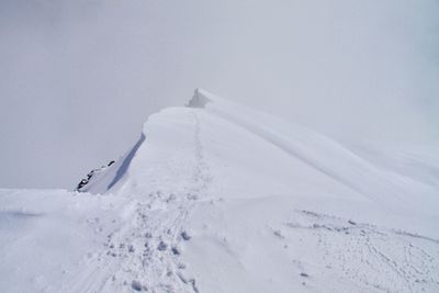 Snow covered land against sky