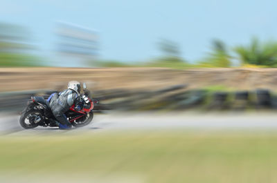 Blurred motion of person riding motorcycle on road