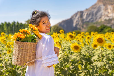 View of girl with yellow flowers on field