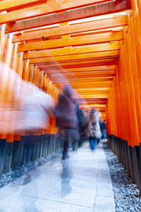 Blurred motion of people walking on road in city