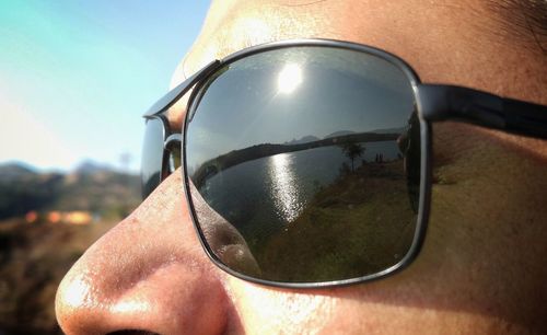 Close-up of sunglasses against sky