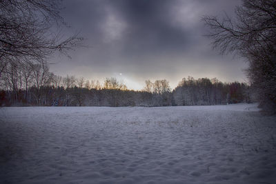 Scenic view of snow covered field against sky