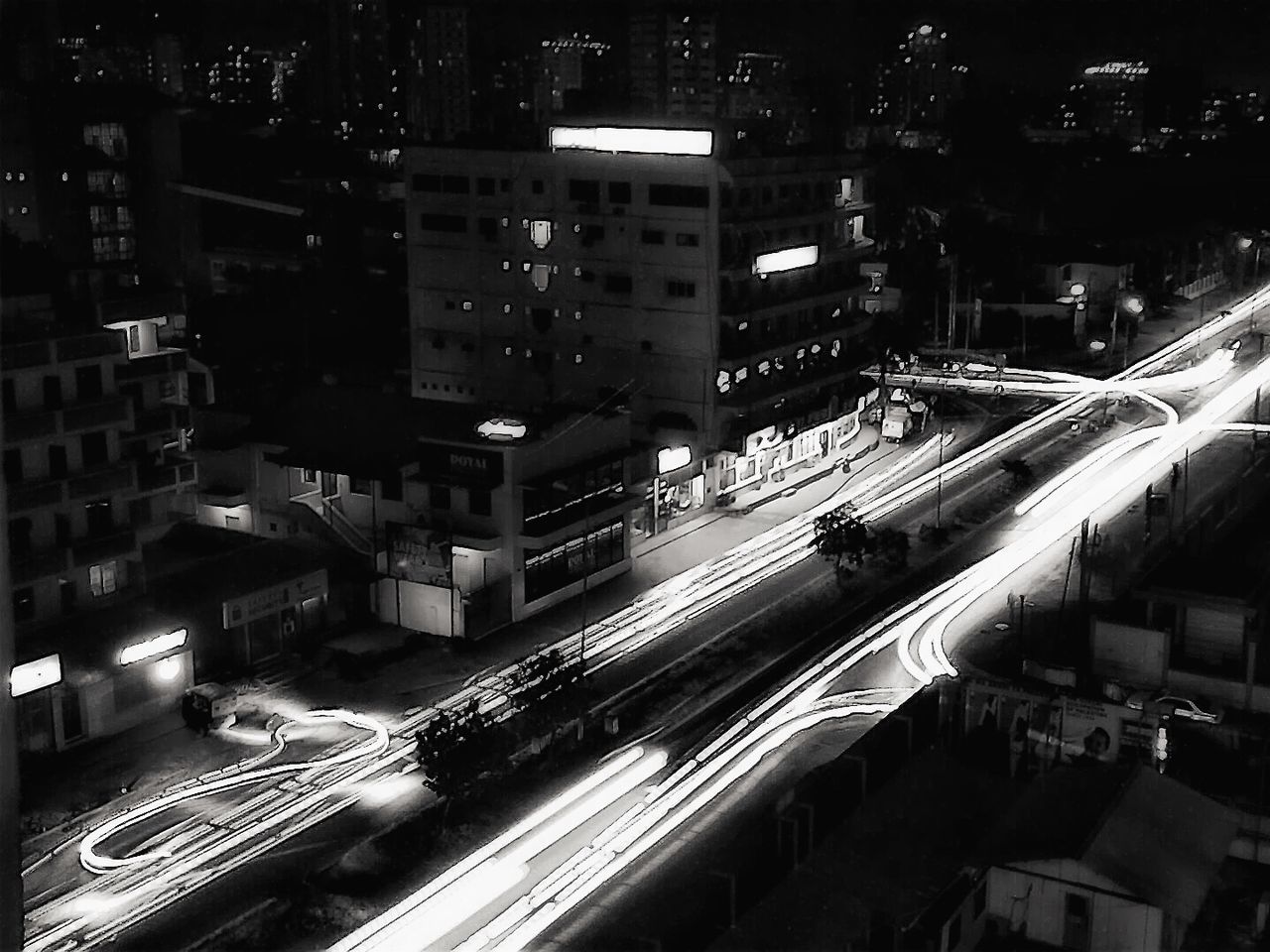 city, building exterior, architecture, built structure, transportation, illuminated, high angle view, night, car, city life, road, street, traffic, cityscape, city street, land vehicle, mode of transport, on the move, road marking, outdoors