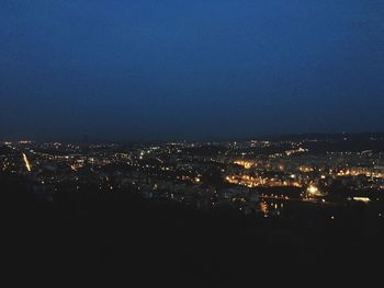 Illuminated cityscape against sky at night